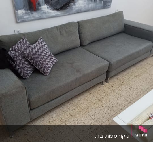 ספה אפורה עם כריות על רצפת אריחים